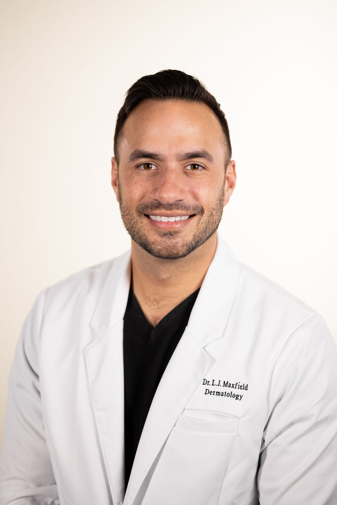 Dr. Luke Maxfield, board-certified dermatologist, in a white lab coat